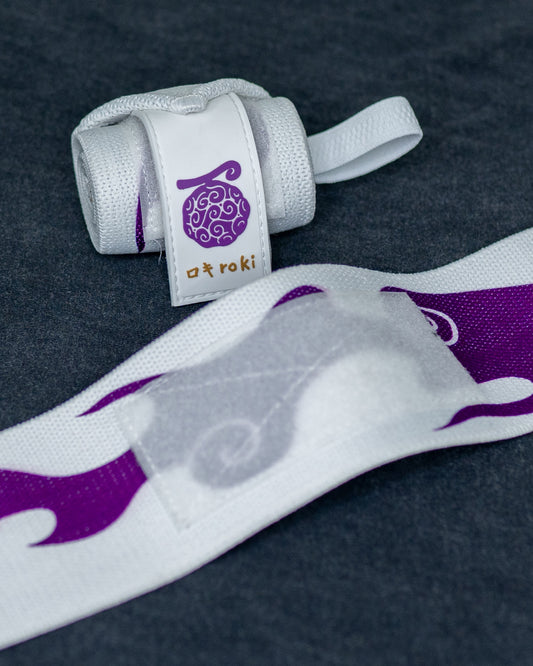 Close-up of white Roki Liberation wrist wraps with purple accents and gold Roki logo