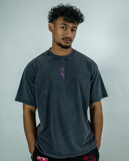 Front view of a model wearing a black Roki muki muki oversized t-shirt featuring a purple Roki logo
