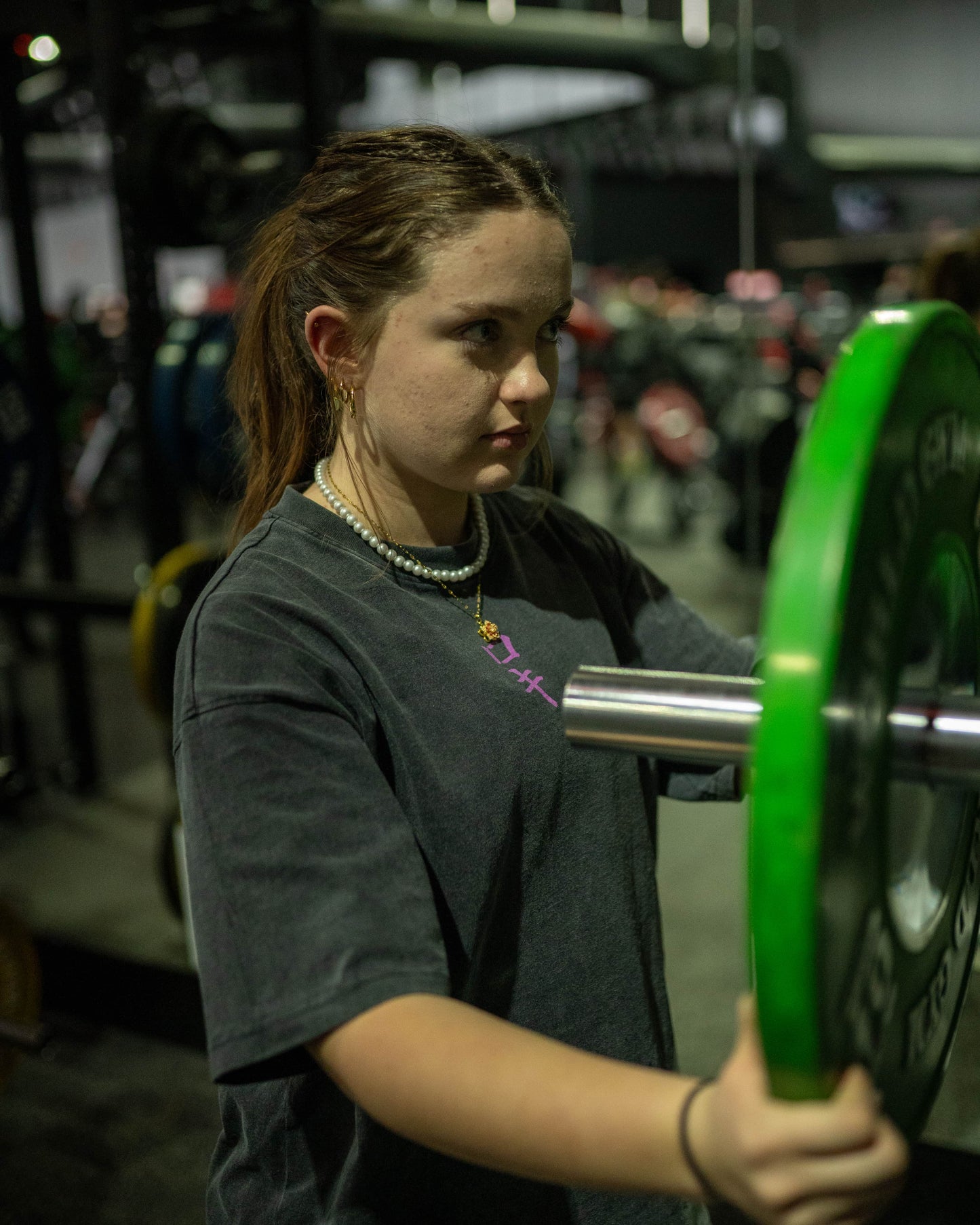 Front view of a model wearing a black Roki muki muki oversized t-shirt in a gym handling plates