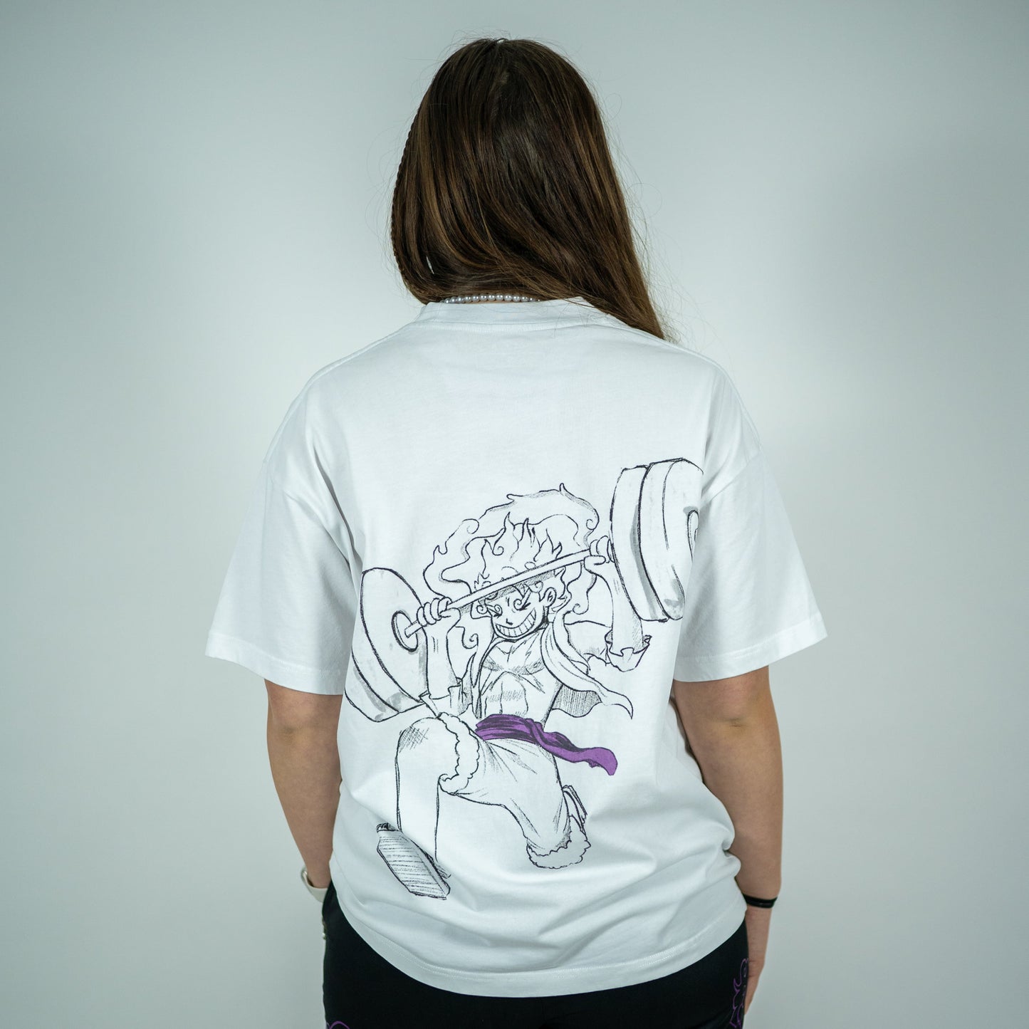 Back view of a model wearing a white Roki muki muki oversized t-shirt featuring a manga-inspired design