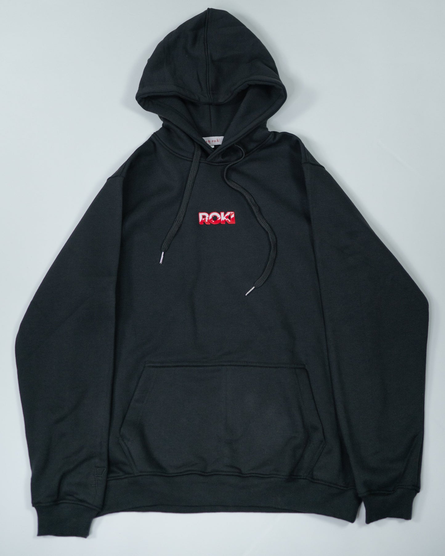 Flatlay of Sekai Saikyo Hoodie showing front view with red ROKI logo on chest and kangaroo pocket