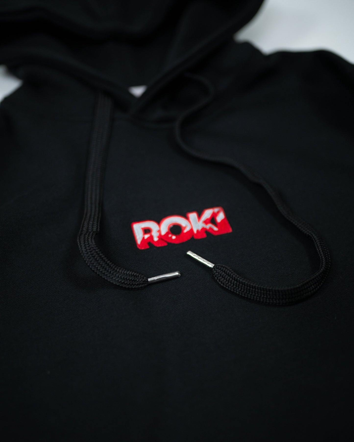 Close-up of Sekai Saikyo Hoodie front chest showing ROKI logo parody of Baki Hanma design with black drawstrings