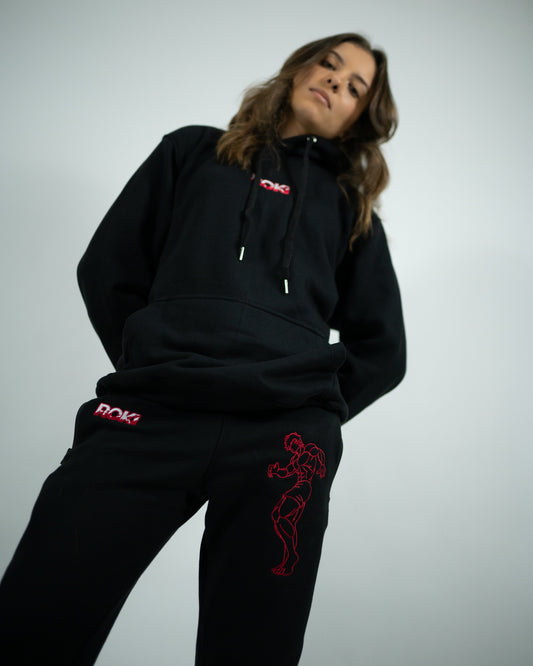 Female model wearing Sekai Saikyo Hoodie with red ROKI logo paired with red embroidered The Grappler Joggers