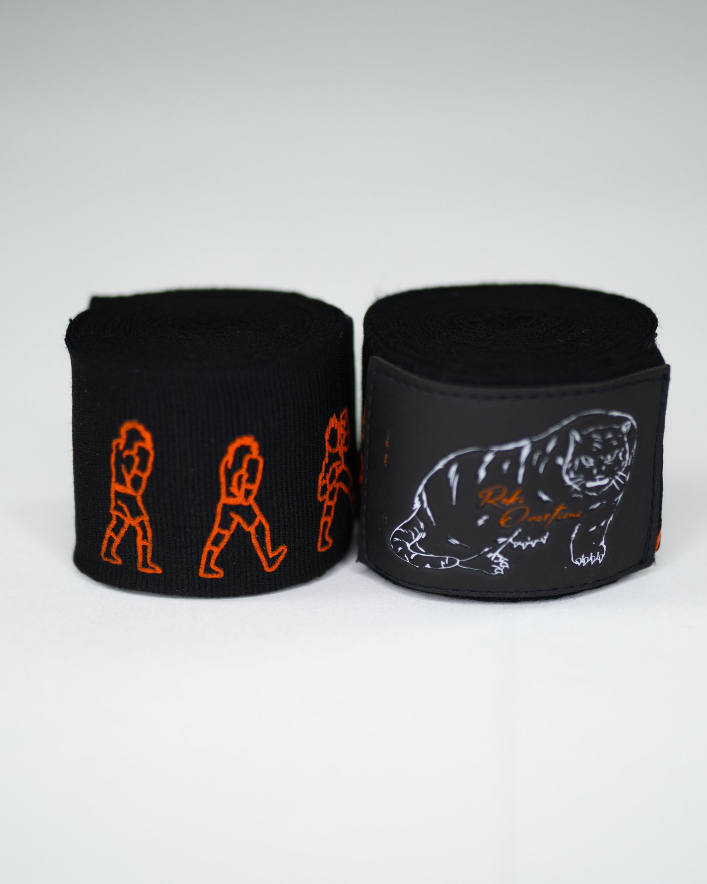 Rolled Sendo boxing hand wraps showing orange fighter graphics and naniwa tiger patch