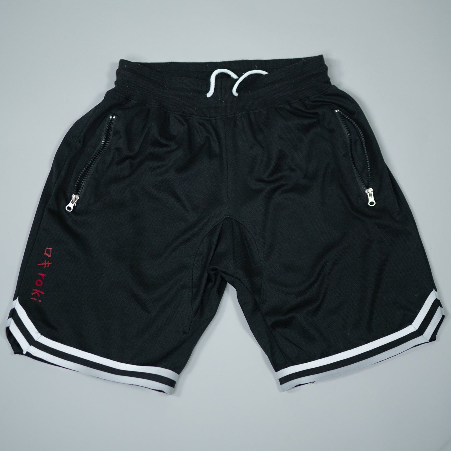 Roki Gym Shorts in black with white trim – lightweight, quick-dry, zipped pockets, and 4-way stretch for gym training