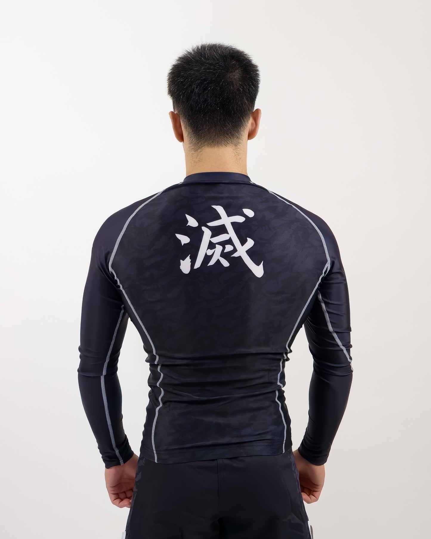 demon slayer rash guard being worn by man, back view of design
