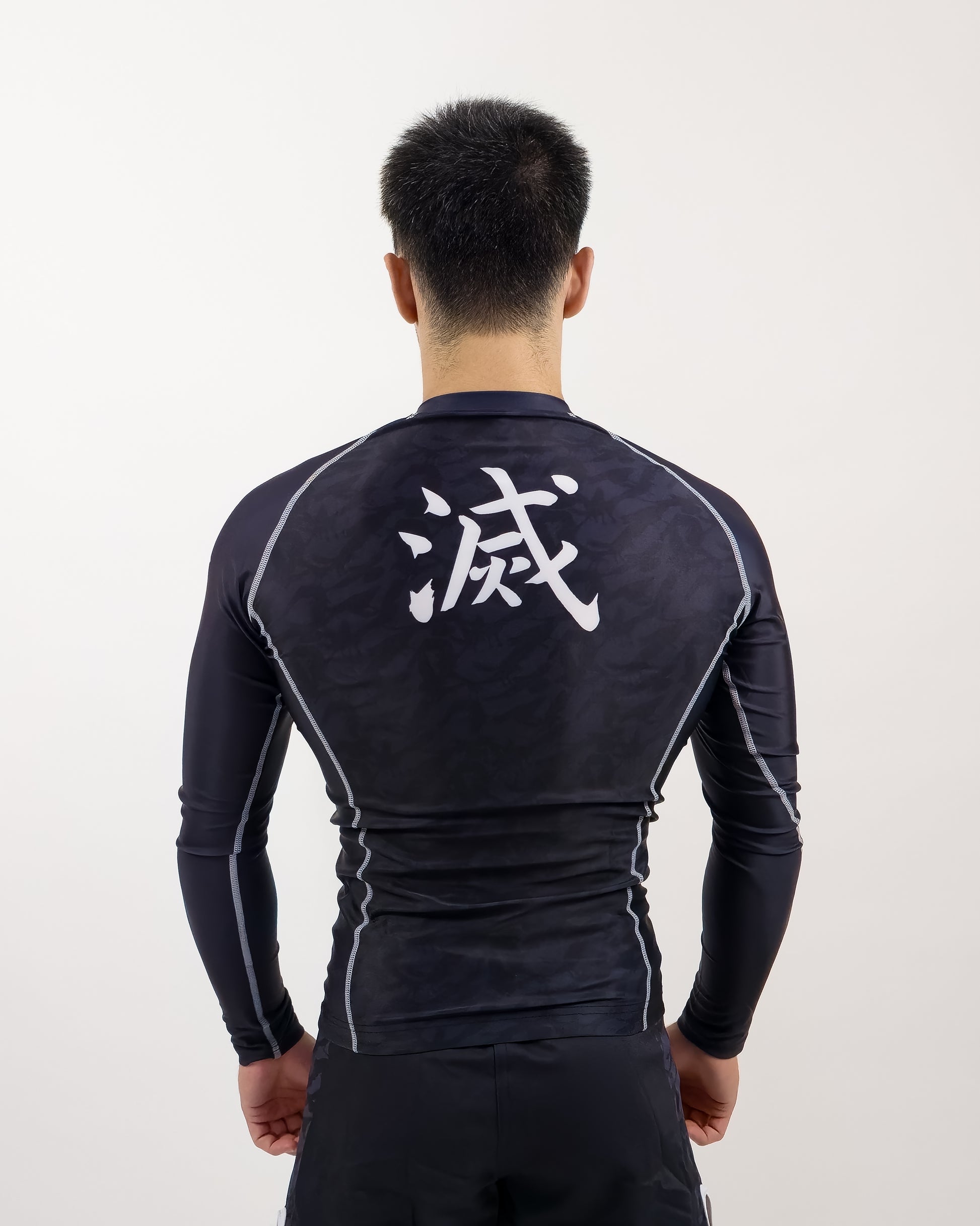 demon slayer rash guard being worn by man, back view of design