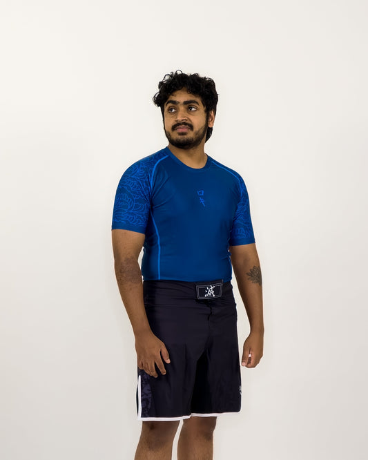 Man wearing a blue shirt and black shorts on a white background