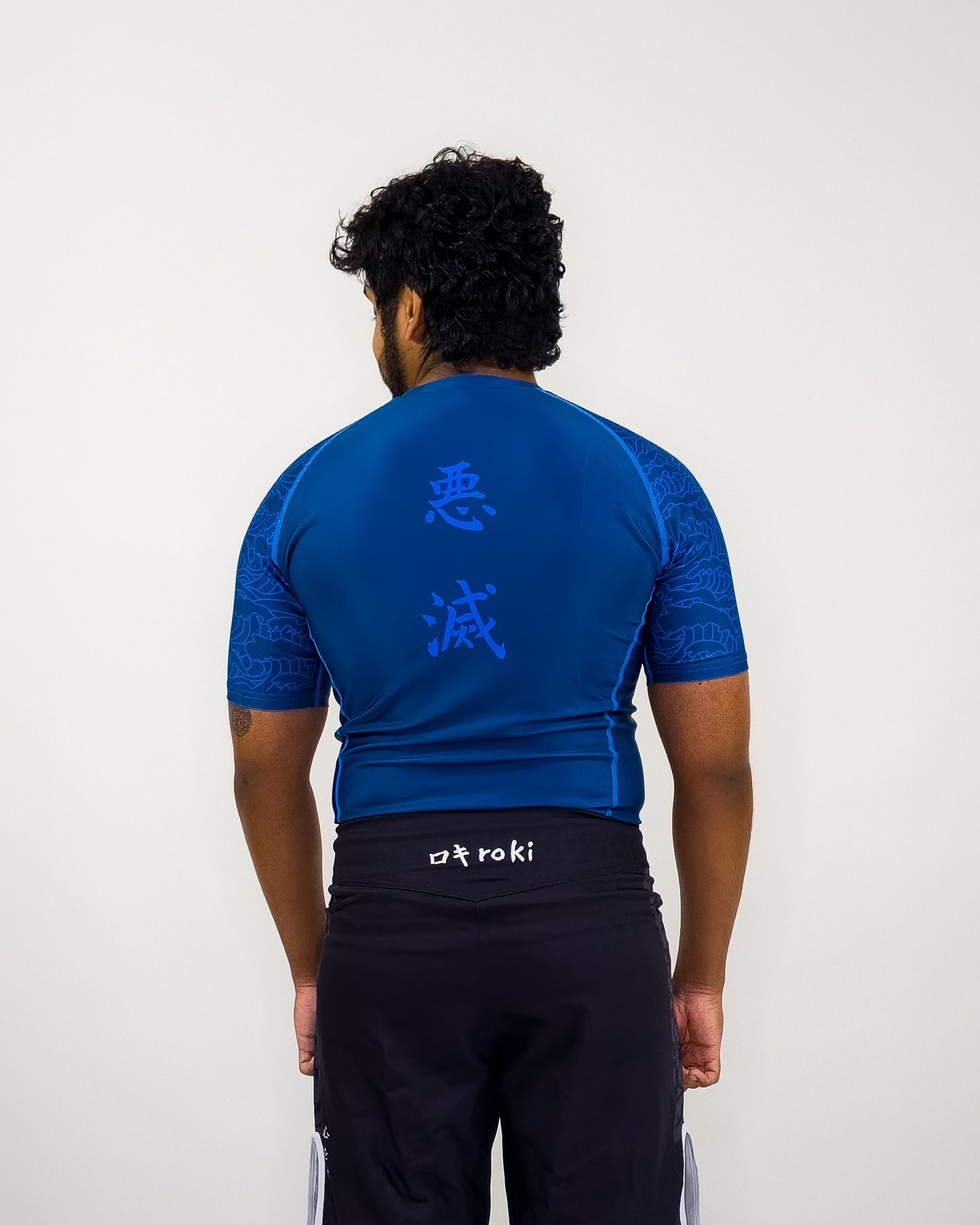water breathing blue demon slayer rash guard worn by man on white background