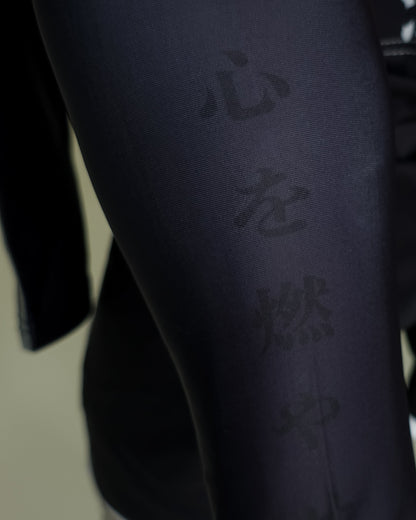 Black martial arts uniform with text on a neutral background
