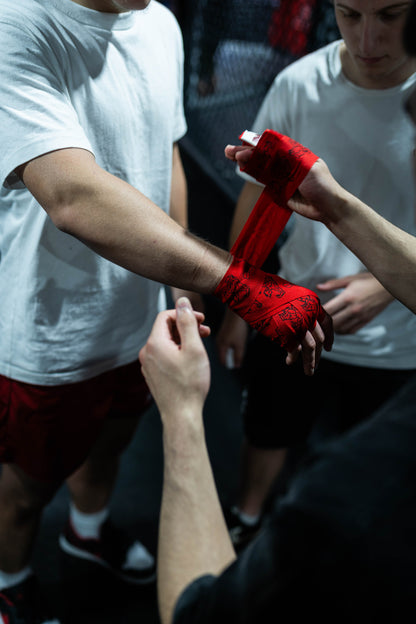 Team wrapping fighter's hand with Baki anime hand wraps