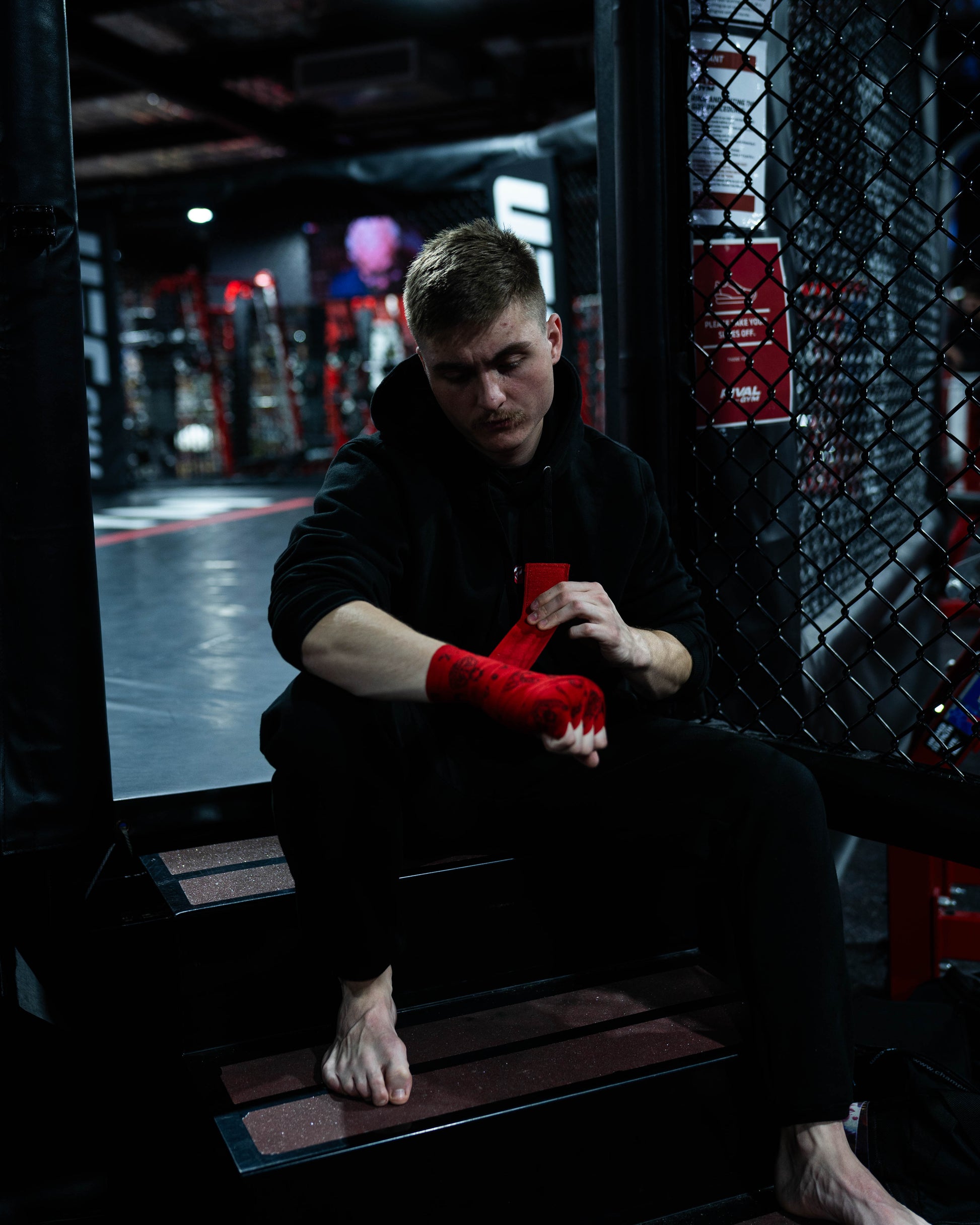 Fighter sitting and wrapping hands with Baki anime hand wraps