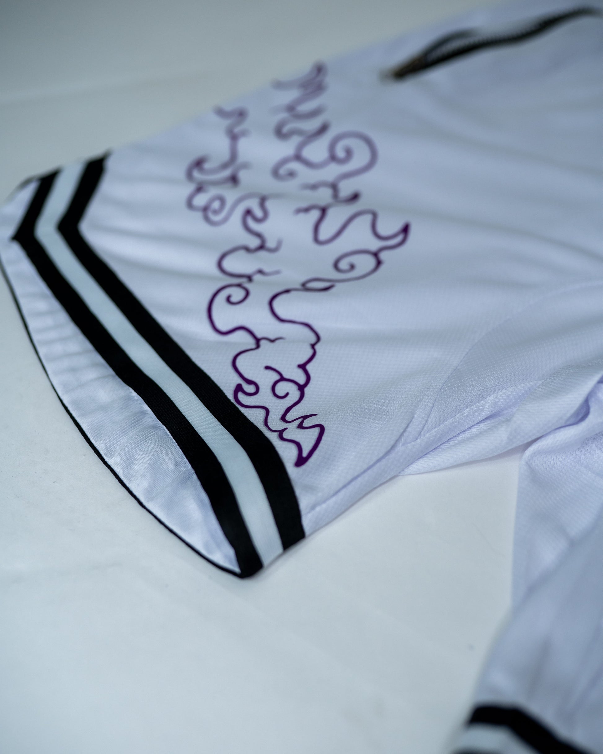 Close-up of white Roki Awakened gym shorts featuring purple accents and Roki logo