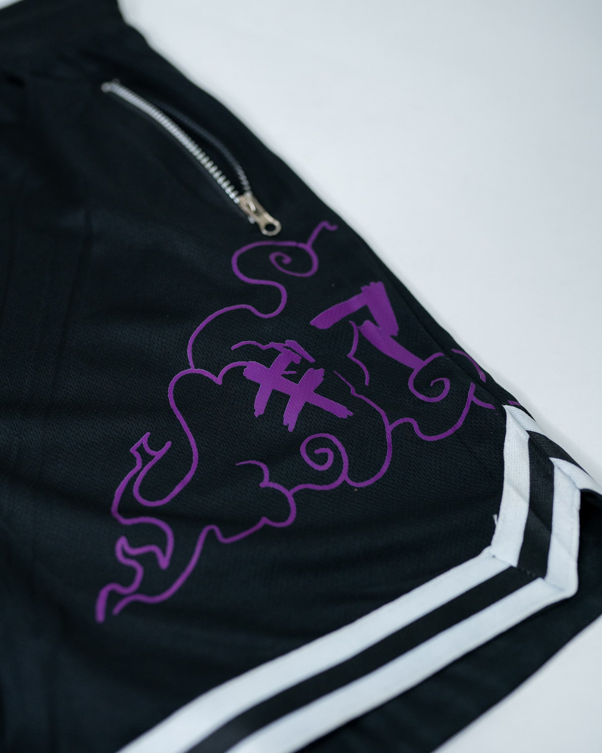 Close-up of black Roki Awakened gym shorts featuring purple accents and Roki logo