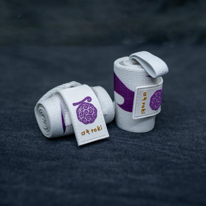 Close-up of white Roki Liberation wrist wraps with purple accents and gold Roki logo
