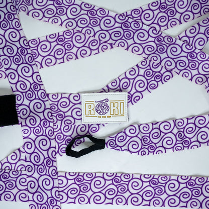 Roki gomu hand wraps laid out, featuring purple accents, roki logo, thumb-loop and velcro patch