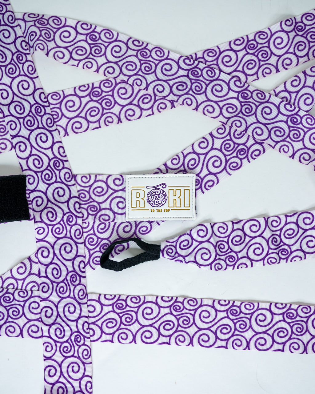 Roki gomu hand wraps laid out, featuring purple accents, roki logo, thumb-loop and velcro patch