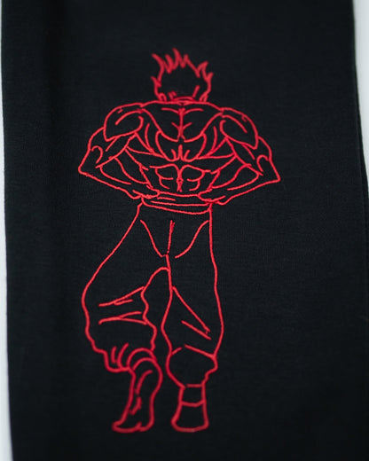 Close-up of Grappler Joggers lower leg showing red embroidery of back-facing demon back character on black fabric