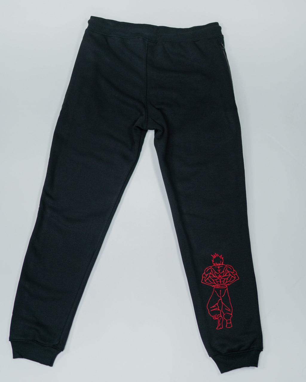 Flatlay of Grappler Joggers back view showing red embroidered demon back character on lower leg