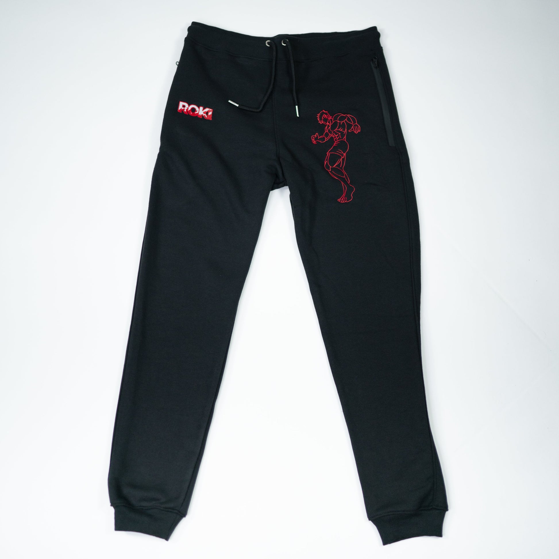 Flatlay of Grappler Joggers featuring red ROKI logo and demon back character embroidery on black sweatpants