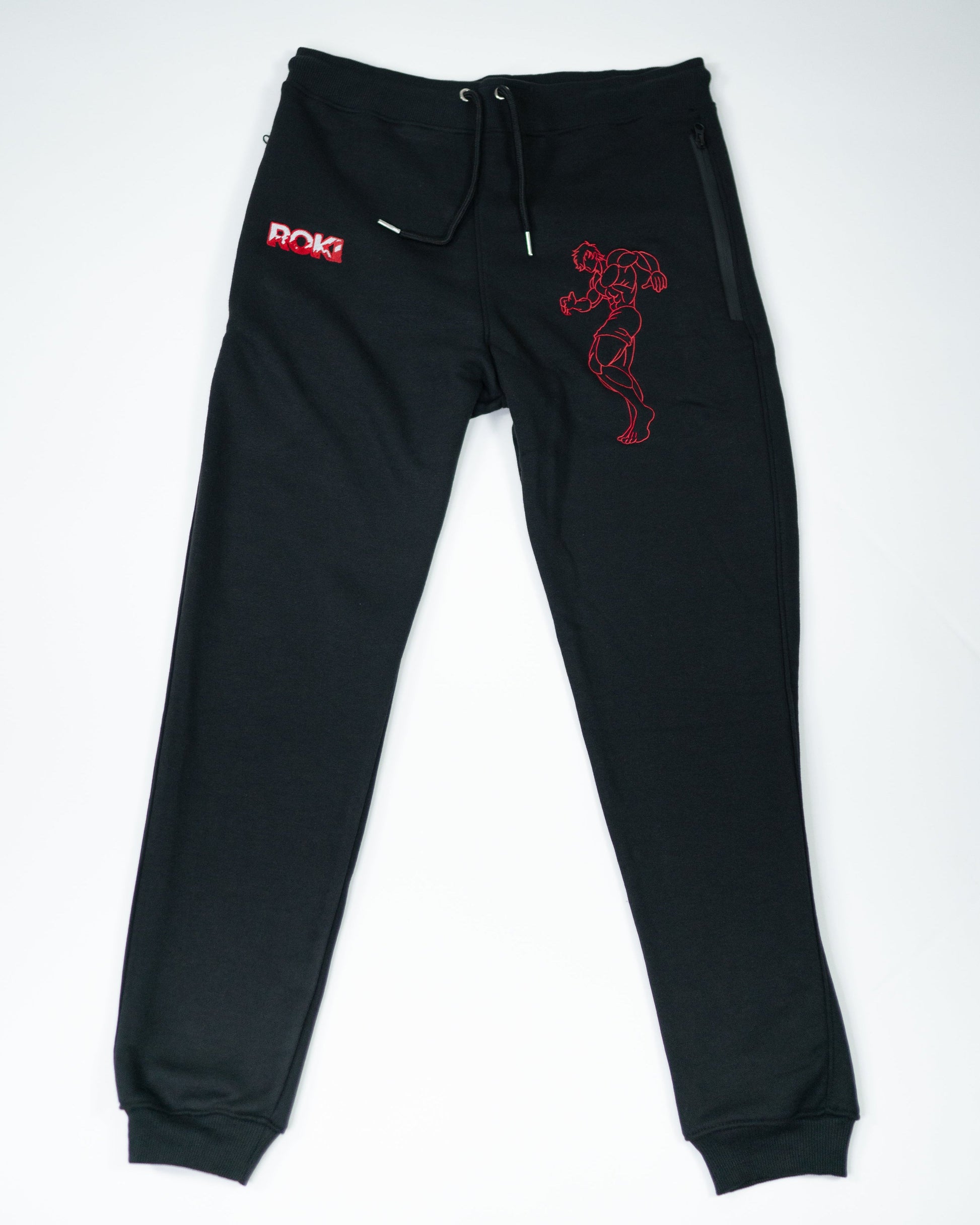 Flatlay of Grappler Joggers featuring red ROKI logo and demon back character embroidery on black sweatpants