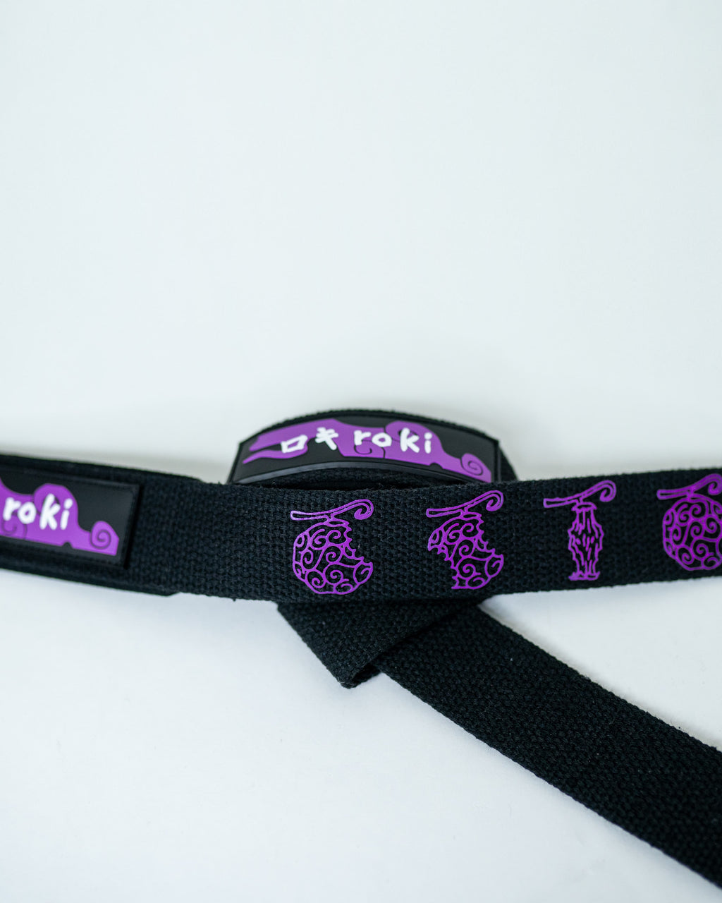 Close-up of black Roki fruit lifting straps featuring purple accents