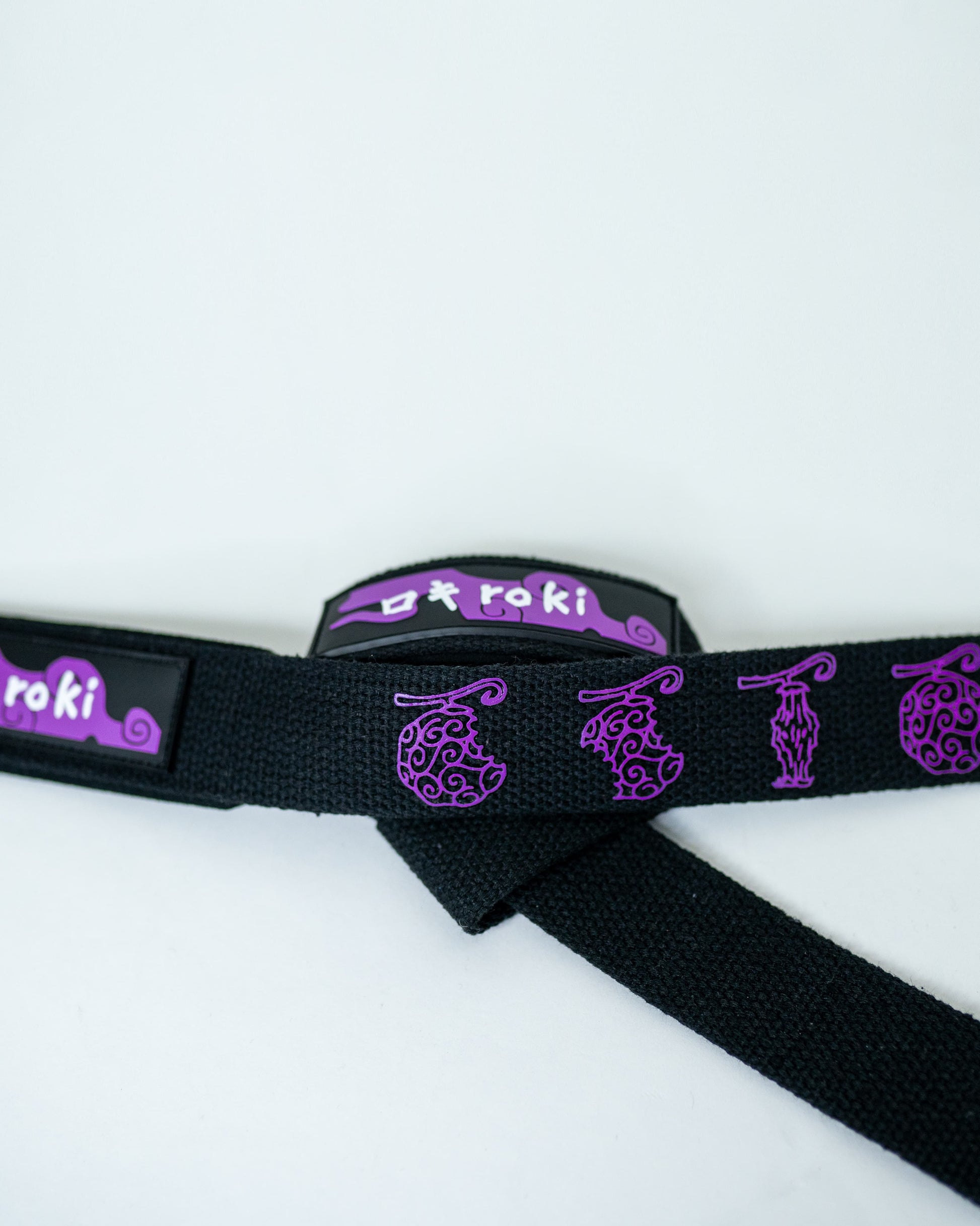 Close-up of black Roki fruit lifting straps featuring purple accents