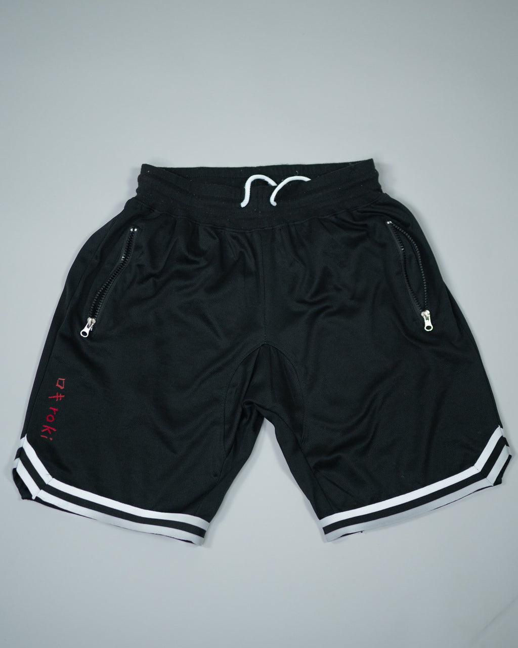 Roki Gym Shorts in black with white trim – lightweight, quick-dry, zipped pockets, and 4-way stretch for gym training