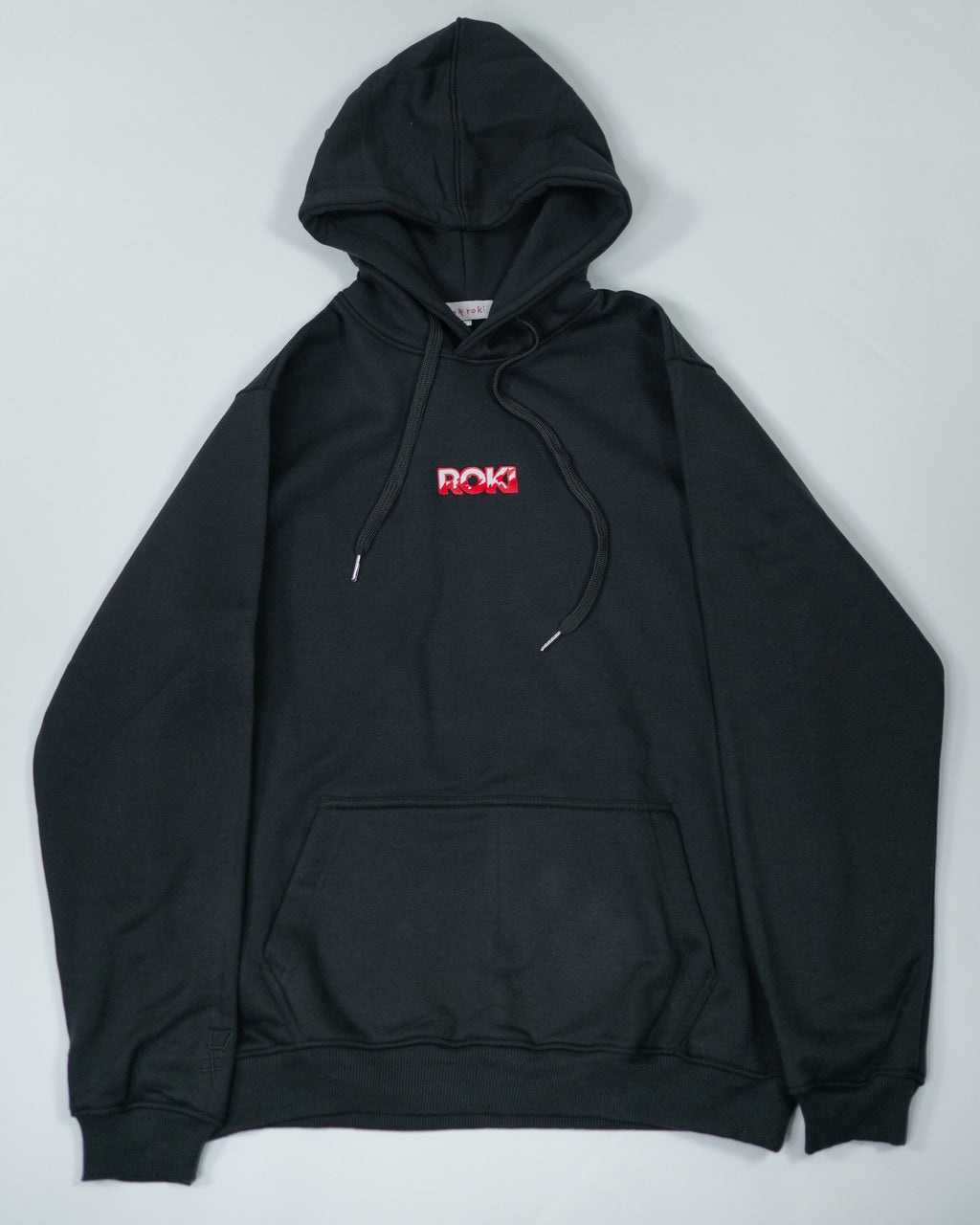 Flatlay of Sekai Saikyo Hoodie showing front view with red ROKI logo on chest and kangaroo pocket