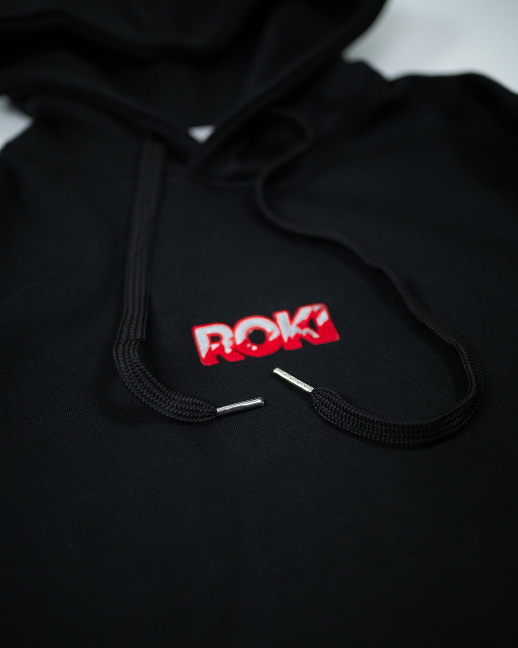 Close-up of Sekai Saikyo Hoodie front chest showing ROKI logo parody of Baki Hanma design with black drawstrings