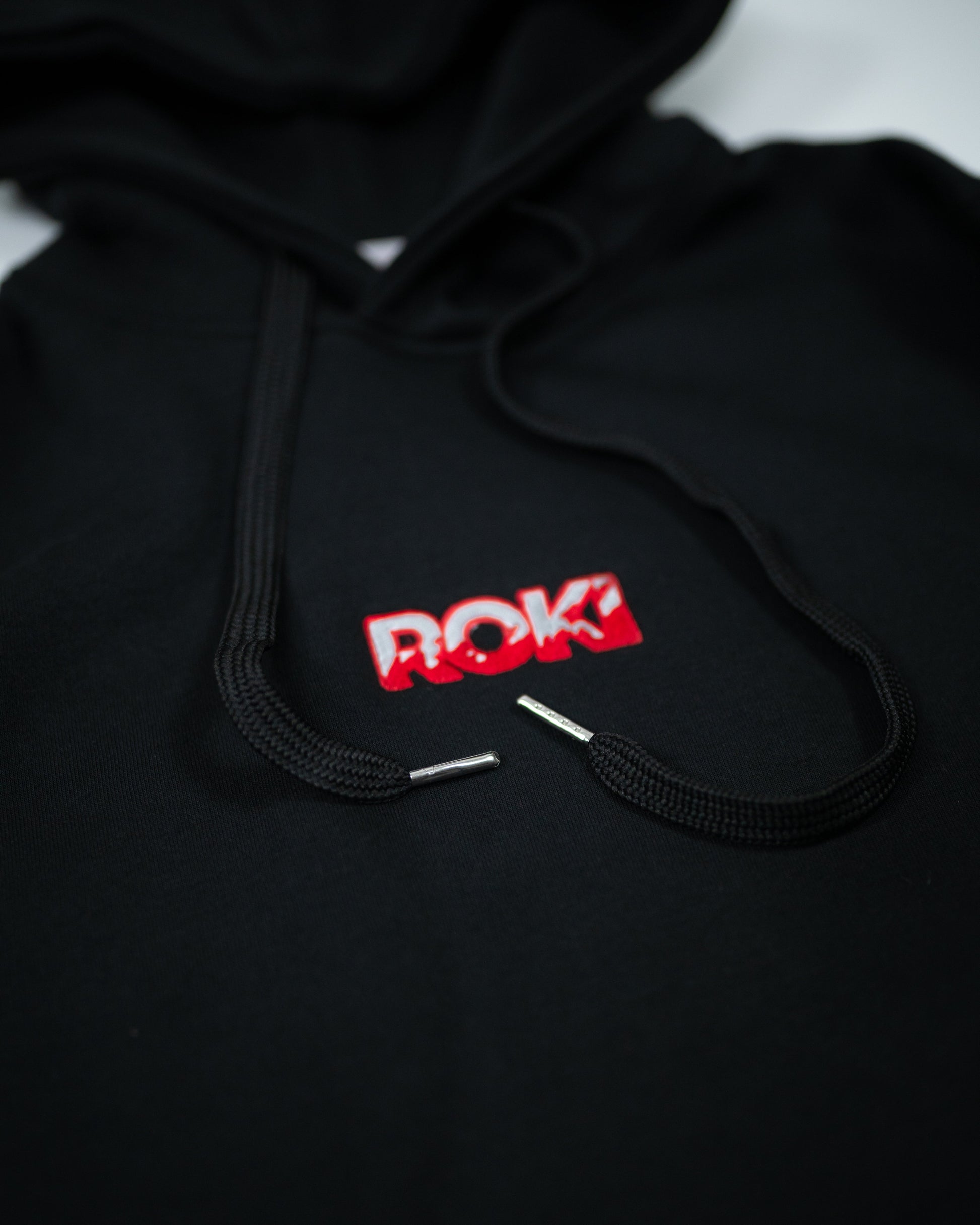 Close-up of Sekai Saikyo Hoodie front chest showing ROKI logo parody of Baki Hanma design with black drawstrings