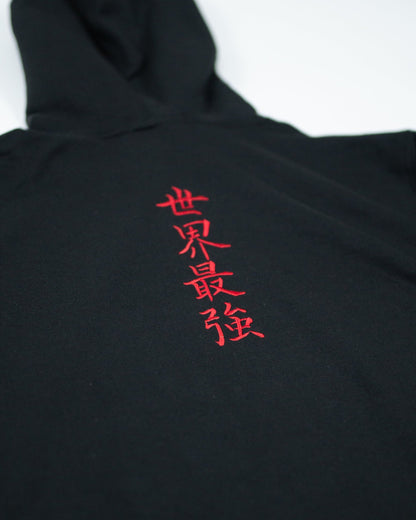 Close-up of Sekai Saikyo Hoodie showing red embroidered kanji reading world's strongest on black fabric
