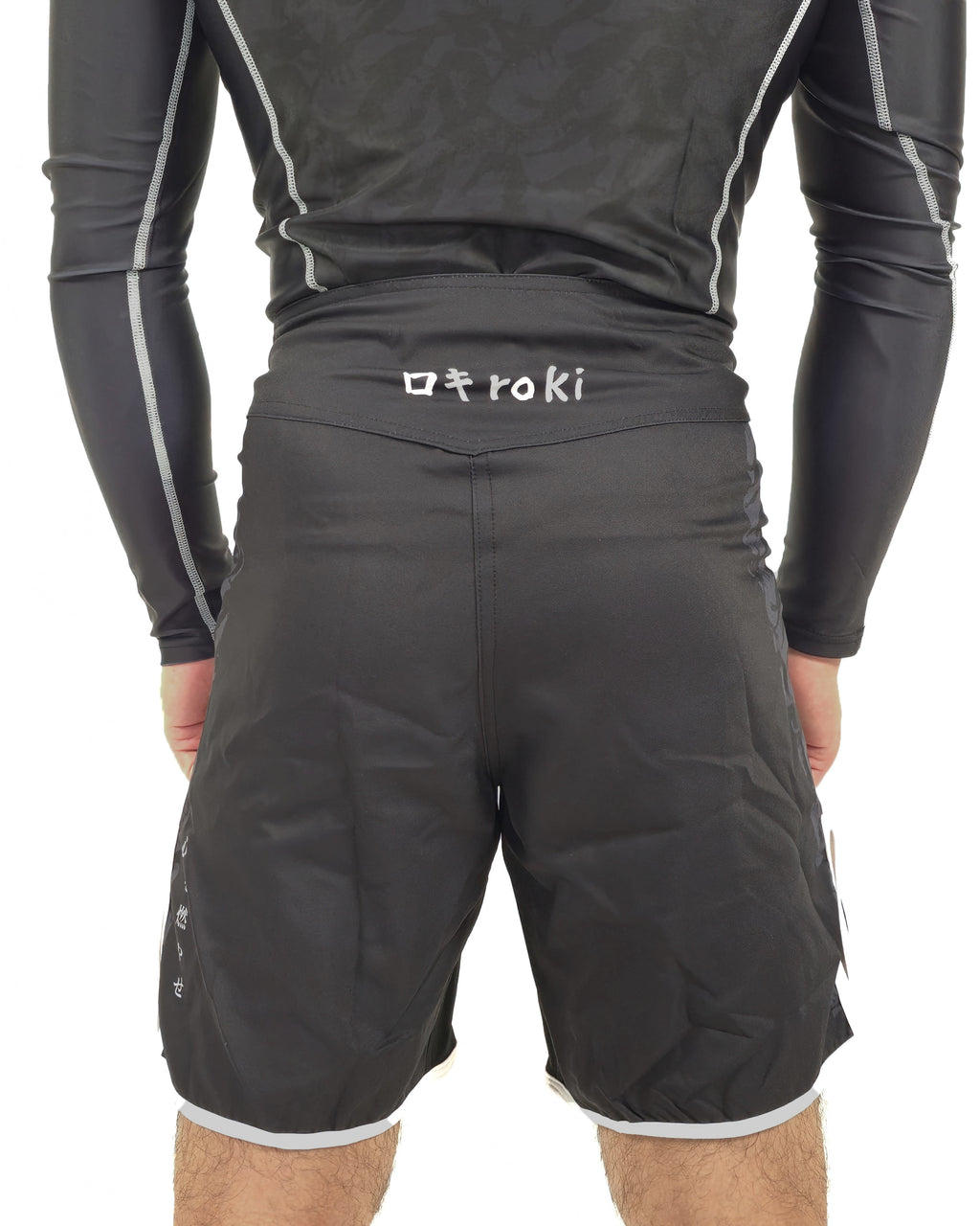 Person wearing black athletic shorts with a brand logo on a white background