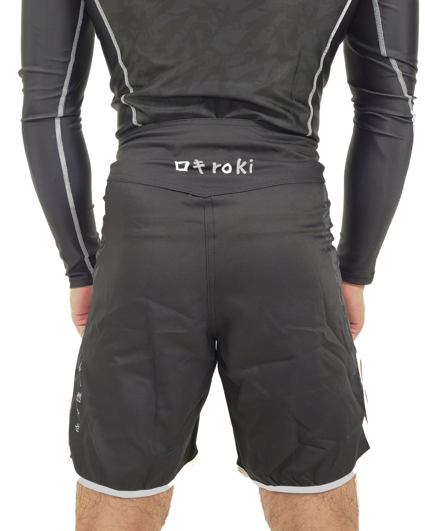 Person wearing black athletic shorts with a brand logo on a white background