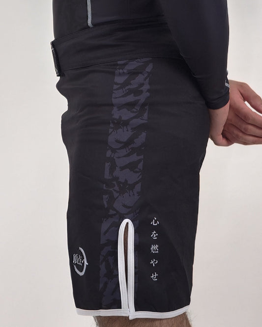 Side view of roki demon slayer mma shorts with crow and kanji features with white accents on a plain background