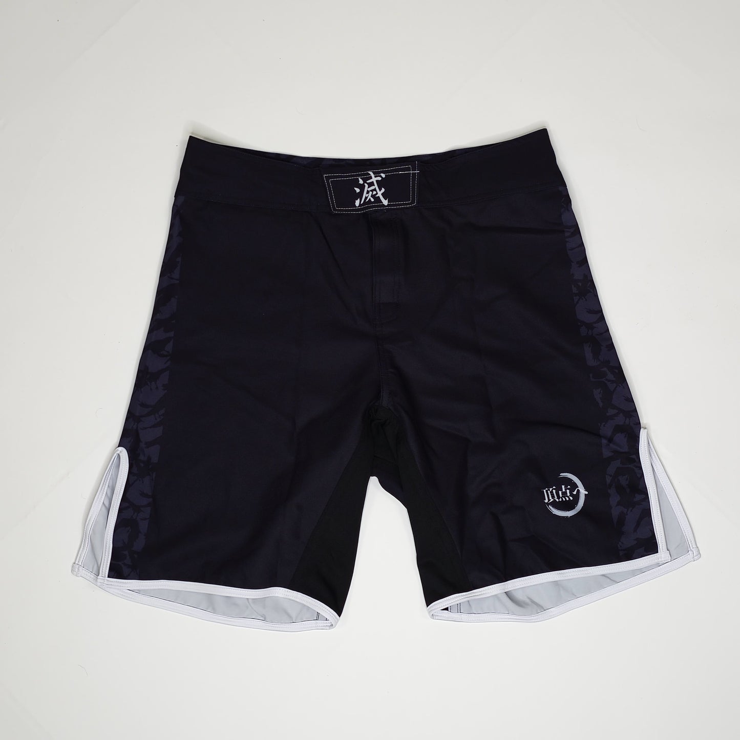 Black demon slayer shorts with white accents on a light gray background